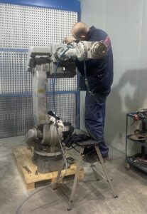 Técnico arreglando un brazo robótico para su posterior uso como robot de segunda mano reacondicionado