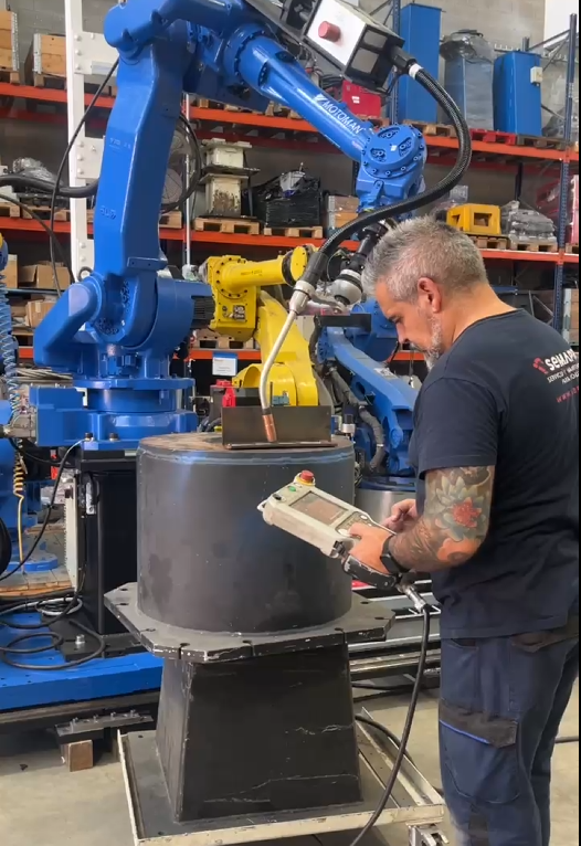 técnico comprobando robot industrial reacondicionado en funcionamiento