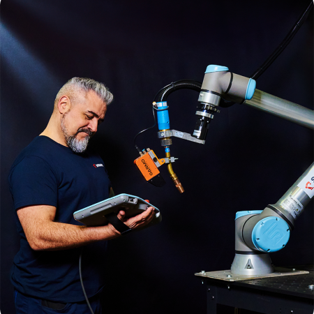 Técnico de una empresa de robots colaborativos programando un robot de soldadura de la marca eurobots para una empresa de la industria